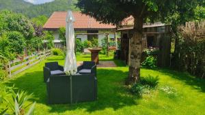 a garden with two chairs and an umbrella at Pension Bergblick in Ruhpolding