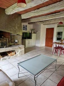 sala de estar con mesa y chimenea en La Fontaine d'Aubrac, en Florentin-la-Capelle