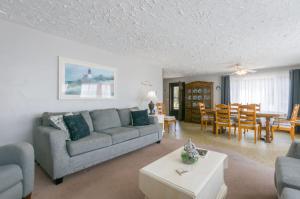 ein Wohnzimmer mit Sofa und Tisch in der Unterkunft 5 Bryant Road Bourne Sunset Cottage in Buzzards Bay