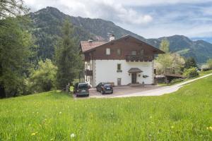 a large house with two cars parked in front of it at Cësa Gravina Suaut in Ortisei