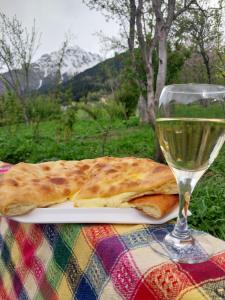 a plate of food with a glass of wine at Guesthouse Leno in Tsaldashi
