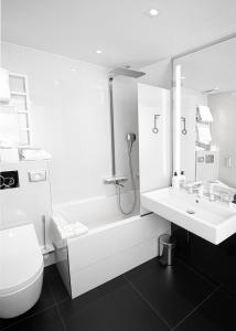 łazienka z umywalką, wanną i toaletą w obiekcie Hôtel Félicien & SPA w Paryżu
