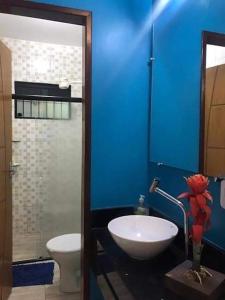 uma casa de banho azul com um lavatório e um WC em CASA TEMPORADA SÃO JOSE DA COROA GRANDE - PE em São José da Coroa Grande