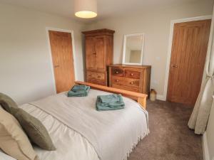 a bedroom with a bed with two towels on it at The Hollow in Hexham