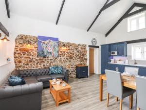 a living room with a couch and a brick wall at Strawberry Bank - Kingfisher in Holsworthy