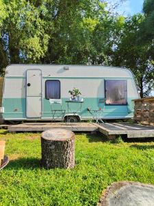 uma caravana azul e branca estacionada na relva em La « Ravane » em Cysoing