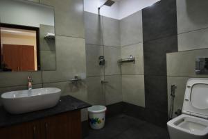 uma casa de banho com um lavatório, um WC e um espelho. em ARAKKAL GUESTHOUSE em Kalpetta