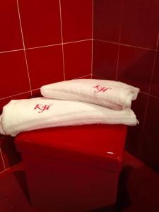 a red bathroom with two white towels on a red box at Kalza House in Palermo