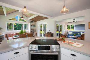 a kitchen with white cabinets and a stove top oven at Kaiana Villa in Princeville