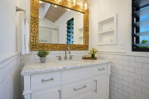 a white bathroom with a sink and a mirror at Kaiana Villa in Princeville