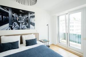 a bedroom with a bed and a large window at Hamilius Apartments City Center Luxembourg by Rentaroo in Luxembourg