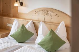 a bed with white and green pillows on it at Residence Diana Apartment 201 in Terento