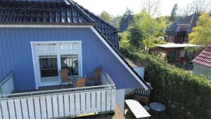 ein blaues Haus mit einem Balkon mit 2 Stühlen in der Unterkunft Kinnekulle 2 in Zingst
