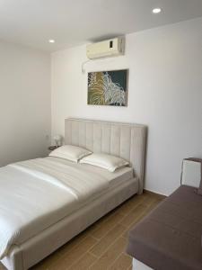 a bedroom with a bed and a air conditioner on the wall at Apartments Basha 1 - Long Beach in Ulcinj