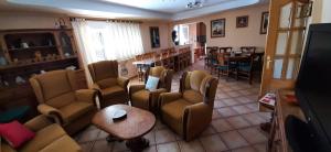 uma sala de estar com sofás, uma mesa e cadeiras em Casa Akay em Zorita