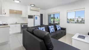 a living room with a couch and a kitchen at Stylish Unit With Water Views in Bellara