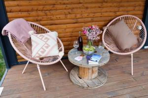 een patio met 2 stoelen en een tafel met wijnglazen bij Tiny Zwick in Apetlon
