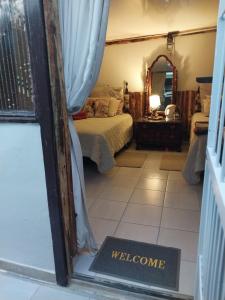 ein Schlafzimmer mit einem Bett und ein Willkommensschild in einem Fenster in der Unterkunft African Elephant's Den in Klerksdorp