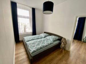 1 dormitorio con 1 cama en una habitación con ventana en Ferienwohnung Castellino, en Kastellaun