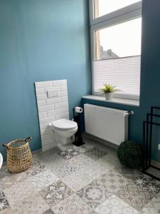 a blue bathroom with a toilet and a window at Ferienwohnung Castellino in Kastellaun