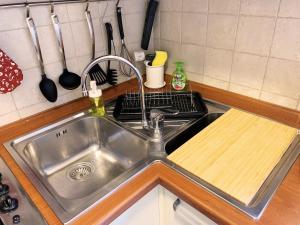 un lavandino in acciaio inossidabile in una cucina con un tagliere di Casa di Arianna in centro storico a Vimercate a Vimercate