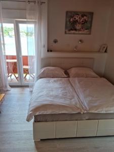 ラブにあるApartments ZALA Matušanのベッドルーム(白いシーツを使用した大型ベッド1台付)