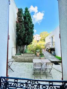 - un groupe de tables et de chaises dans une cour dans l'établissement Le Gamay - Charmant T2 avec parking et Terrasse, à Châtel-Guyon