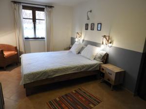 een slaapkamer met een bed, een stoel en een raam bij La Piccola Scoperta in Acqui Terme