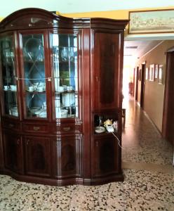 a large wooden cabinet with glass doors in a hallway at B&B Fenice Barocca in Lecce