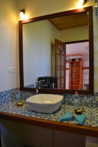 W łazience znajduje się umywalka i lustro. w obiekcie Hotel Ambalakely w mieście Ambalakely
