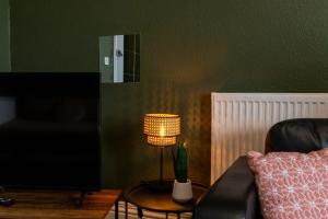a living room with a couch and a table with a lamp at Digbeth City Centre Apartment Sleeps 12 Opposite Coach Station in Birmingham