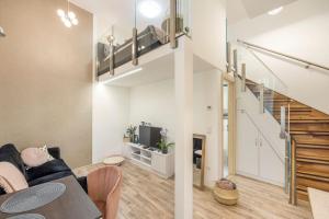 - un salon avec un canapé et un escalier dans l'établissement Krudy Bijou Budapest Studio, à Budapest