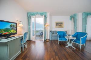 a living room with a television and a table and chairs at Seegarten in Caldaro