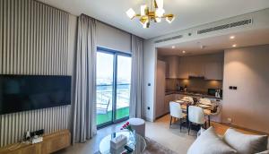 ein Wohnzimmer mit einem großen Fenster und eine Küche in der Unterkunft STAY BY LATINEM Luxury 1BR Holiday Home CVR A2410 near Burj Khalifa in Dubai