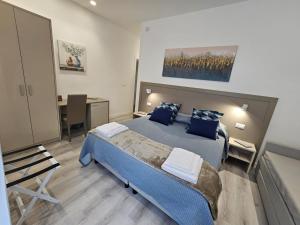 a bedroom with a blue bed and a desk at City Rooms Katane in Catania