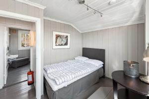 ein Schlafzimmer mit einem Bett in einem Zimmer mit einem Tisch in der Unterkunft Solsiden - in the center of Geilo in Geilo