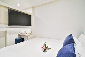 a bedroom with a bed with a tv on the wall at WABA Classic Gwanganri in Busan