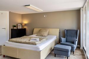 um quarto com uma cama e uma cadeira azul em Tinyhouse Baumann em Quickborn