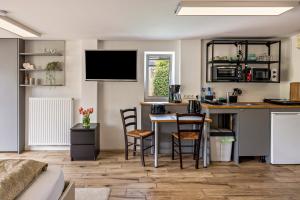 cocina y sala de estar con mesa y sillas en Tinyhouse Baumann, en Quickborn