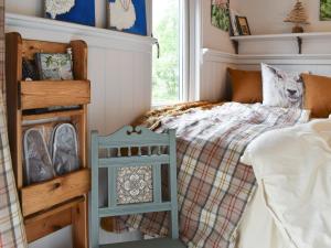 een kleine slaapkamer met een bed en een raam bij Spruce Shepherds Hut in Wilmslow