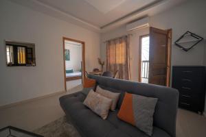 sala de estar con sofá gris con almohadas en Le charmant en Dakar