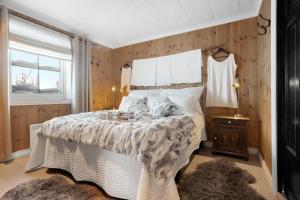 a bedroom with a bed with a white comforter at Guroli - Mountain Lodge in Torvetjørn