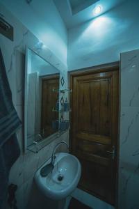 W łazience znajduje się umywalka i lustro. w obiekcie Le charmant w mieście Dakar