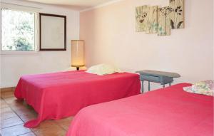 Habitación con 2 camas con sábanas rosas y mesa. en 2 Bedroom Amazing Home In Olargues en Olargues