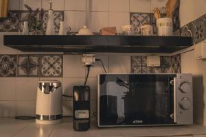 a kitchen with a coffee maker and a microwave at Le charmant in Dakar