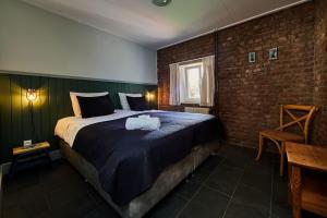 a bedroom with a large bed and a brick wall at Het mooiste uitzicht-De Oogappel in Vijlen