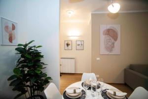 uma sala de jantar com uma mesa e cadeiras brancas em Atmosfere Terrace View Apartment em Bérgamo