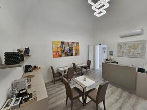 una sala da pranzo con tavoli e sedie e una cucina di City Rooms Katane a Catania
