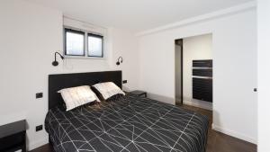 een slaapkamer met een groot zwart bed met 2 kussens bij Le Ruthénois T2 avec terrasse, classé meublé de tourisme in Rodez
