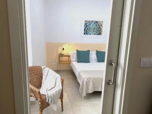 a bedroom with a bed with blue pillows and a chair at Nest Silence in Valencia